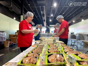 volunteers pack food for Food Packing Event