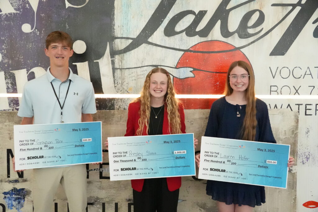 Three scholarship winners hold big checks